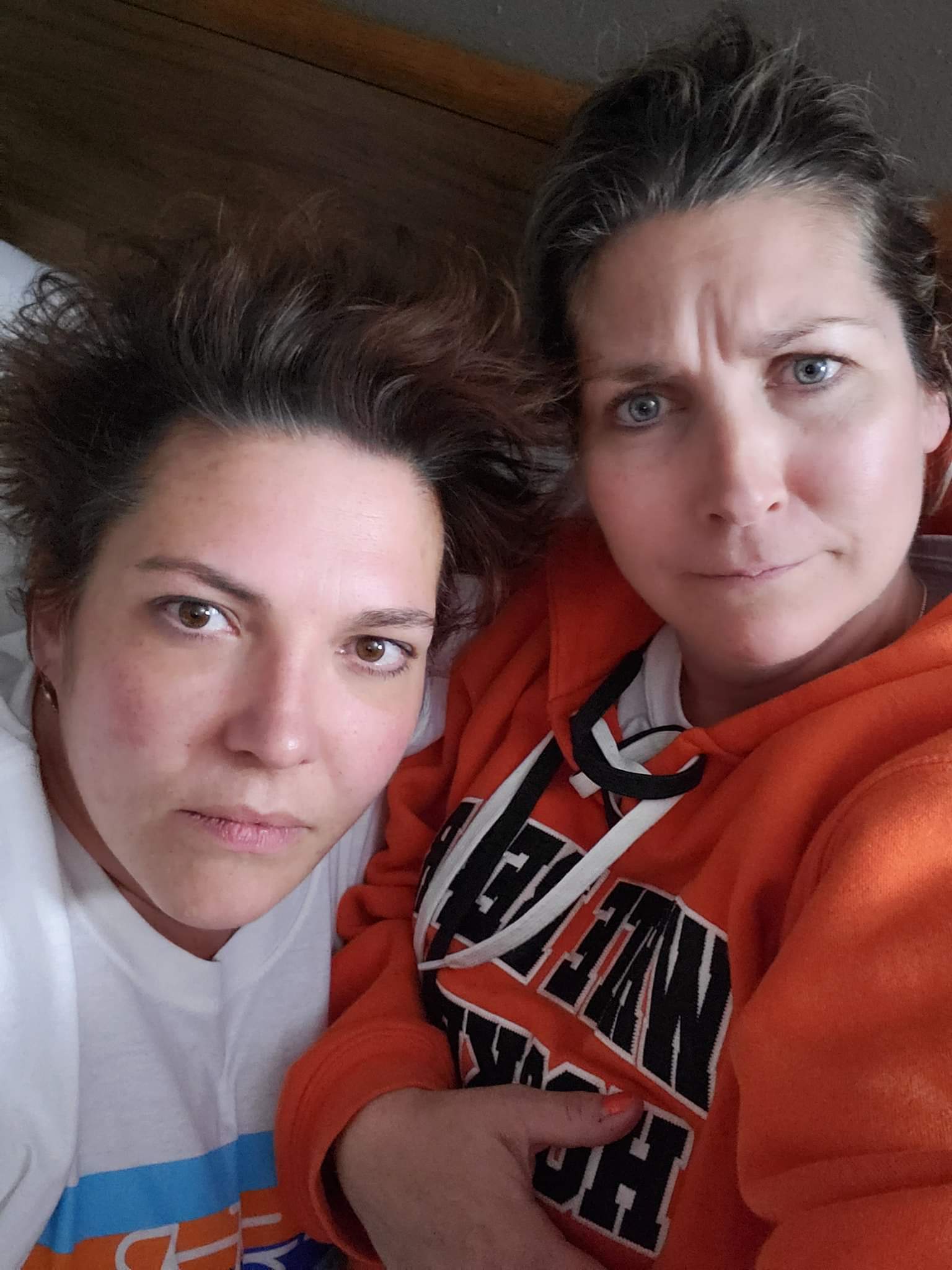 Two riders, one in orange team hoodie